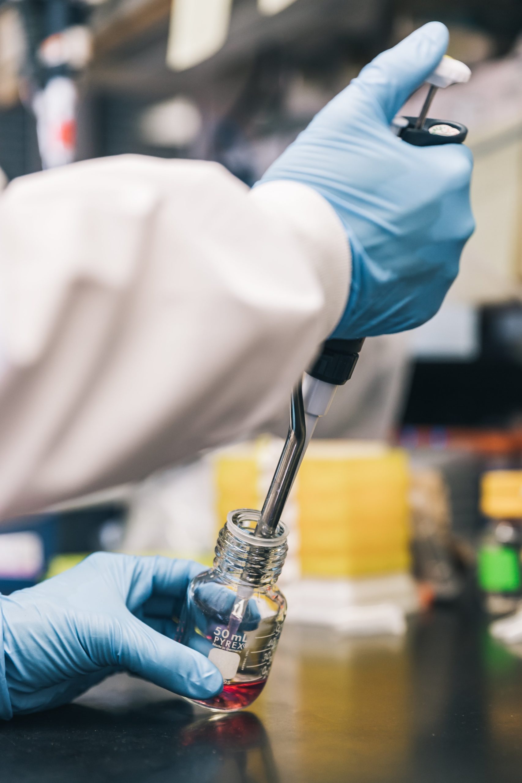 scientist-injecting-red-liquid-into-bottle
